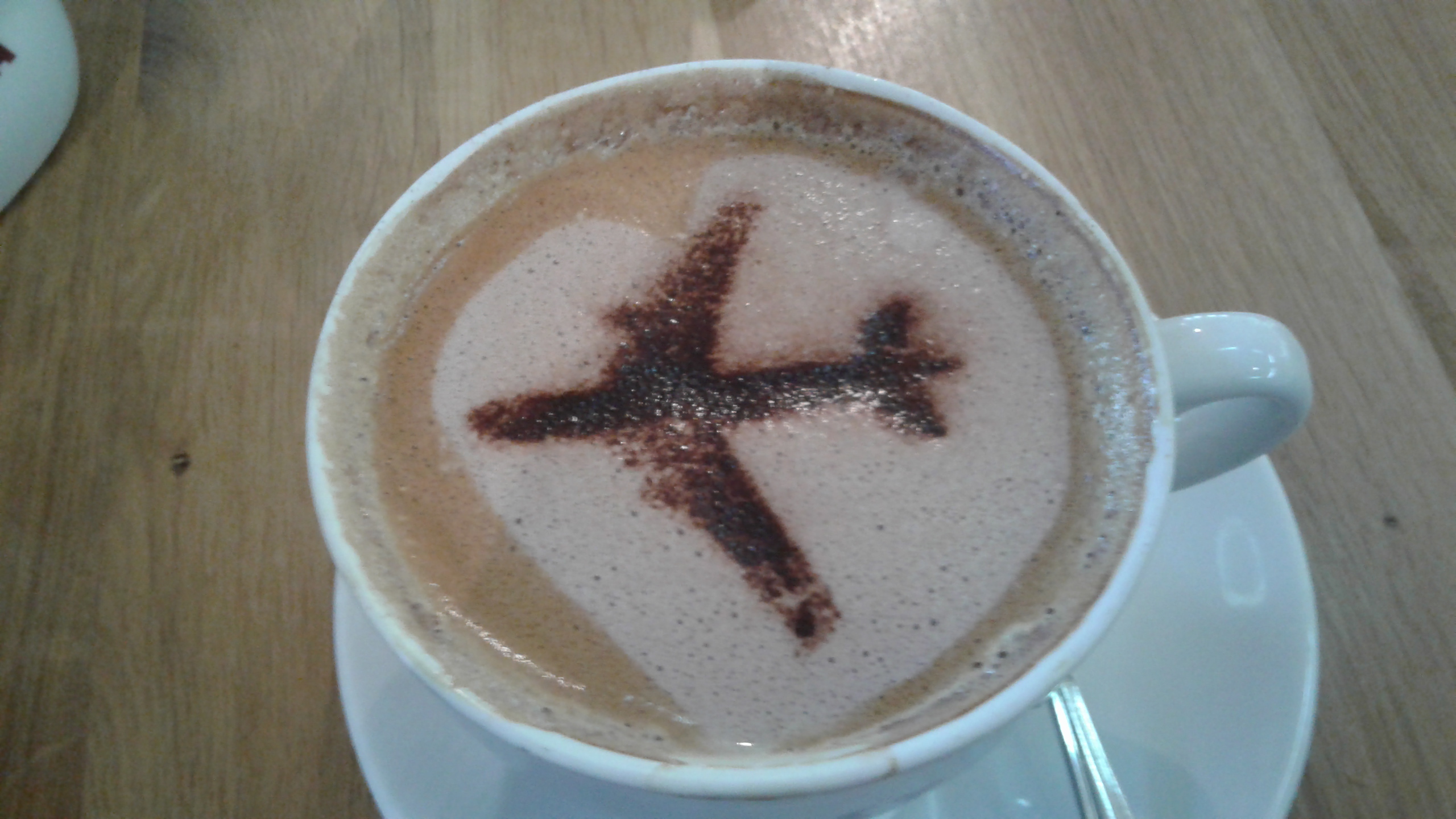 Coffee decorated with cocoa powder in the shape of an airplane